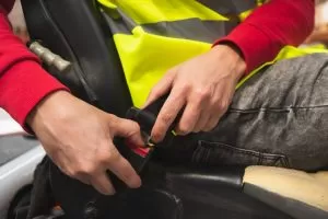 Close Up Of Hands Fastening The Seat Belt Of A Forklift